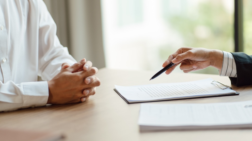 a person pointing to a form with a pen