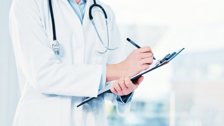 doctor with clipboard writing notes