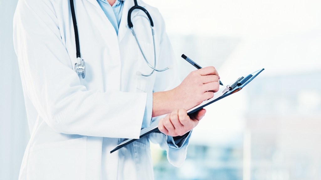 doctor with clipboard writing notes